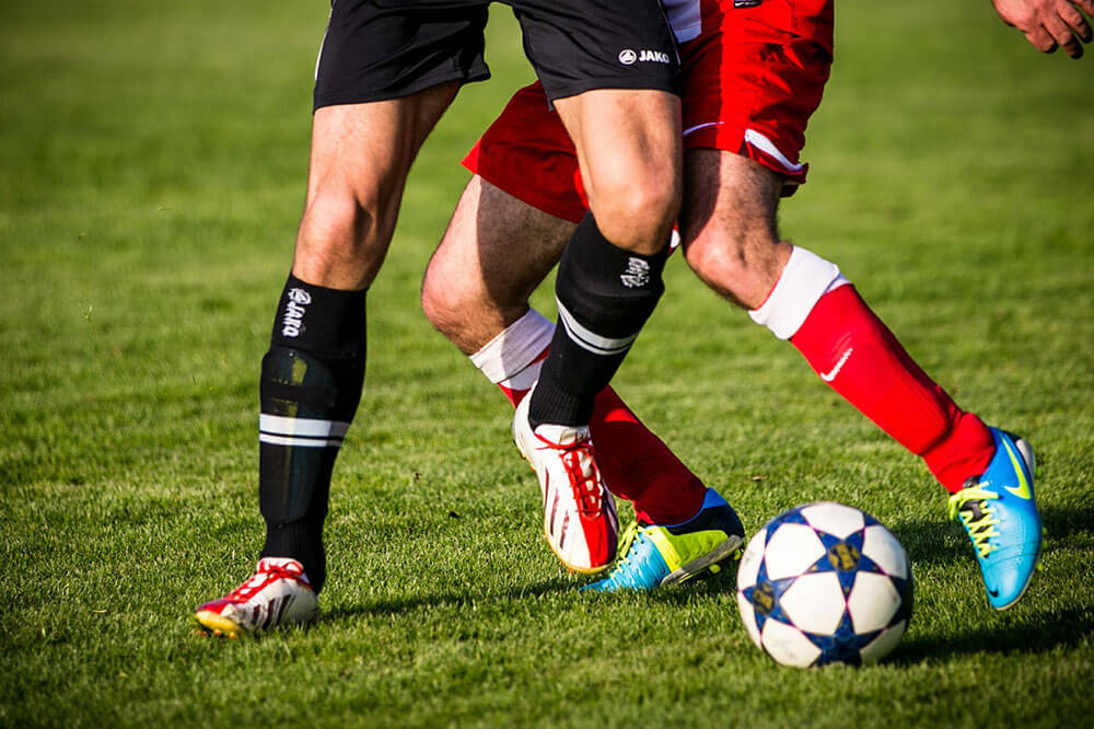 Two male soccer players dribbling the soccer ball