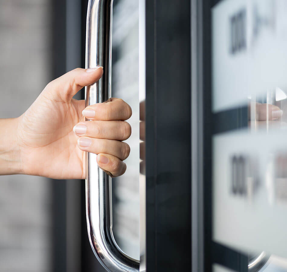 person with hand on door handle for independent medical exam workers' comp case