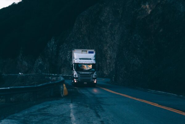A truck driving down an open road at night, on a blog discussing trucking accidents.